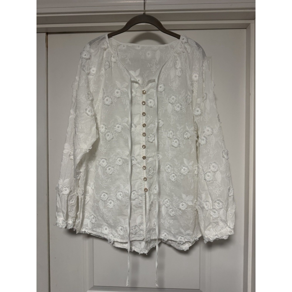 Commense top features intricate floral embroidery and a lace-up front detail